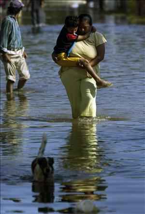 Damnificados caminan por una calle inundada de la ciudad de Villahermosa, en el estado mexicano de Tabasco, castigado recientemente por copiosas lluvias. Fuente EFE.