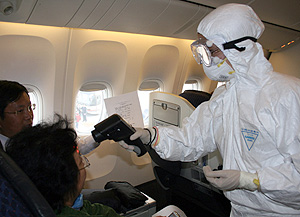 Sanitarios protegidos examinan a pasajeros procedentes de M�xico en el aeropuerto de Shangai (Foto: Getty Images | Zhao Yun)