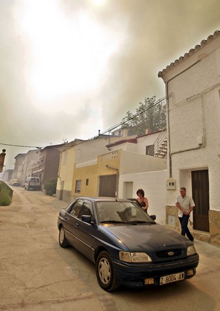 Dos vecinos se disponen a abandonar Valmadrid. | EFE